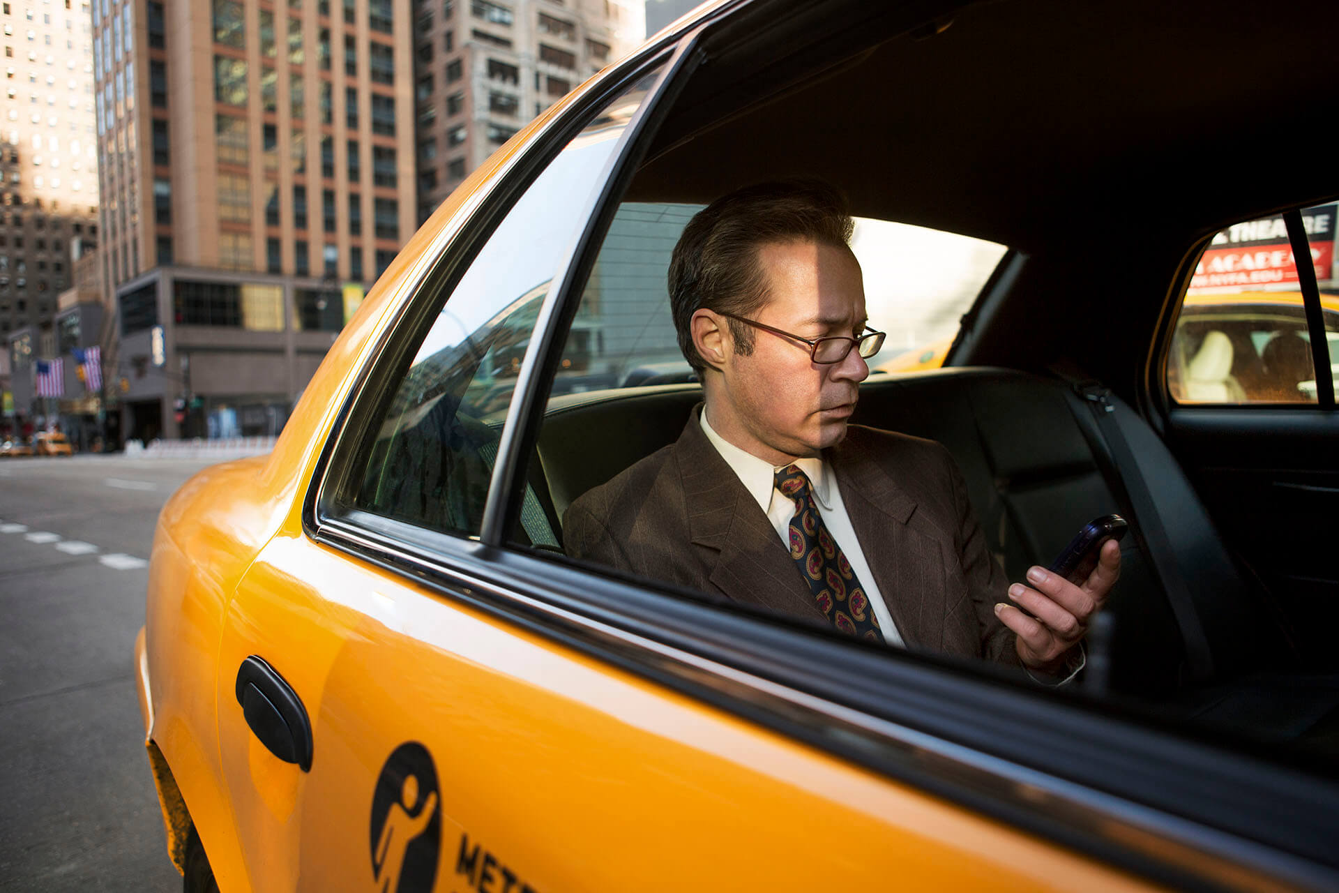 businessman-using-mobile-phone-in-taxi-2022-05-26-00-57-42-utc.jpg